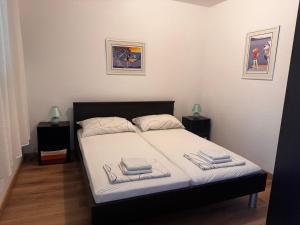 a bedroom with a bed with two night stands and two lamps at Holiday Home Mirta in Pakoštane