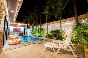a swimming pool with two chairs and a swimming pool at MM Pool Villa in Pattaya South