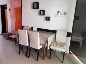 a dining room with a table and white chairs at Holiday Home Mirta in Pakoštane +10 photos