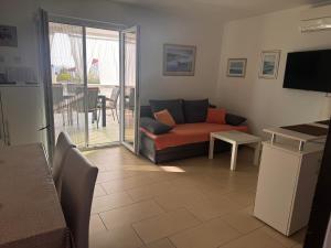 a living room with a couch and a table at Holiday Home Mirta in Pakoštane