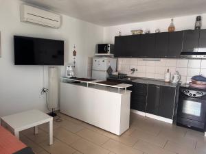 a kitchen with black cabinets and a white counter top at Holiday Home Mirta in Pakoštane