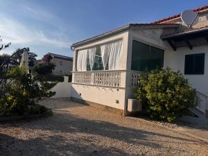 a white house with a balcony on the side of it at Holiday Home Mirta in Pakoštane