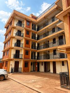 an apartment building with a car parked in front of it at Shan cozy haven in Jinja