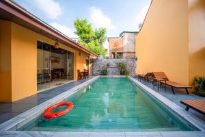 a swimming pool with a red boat in a house at Tam Coc Cosiana Hotel in Ninh Binh