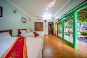a bedroom with two beds and a balcony at Tam Coc Cosiana Hotel in Ninh Binh