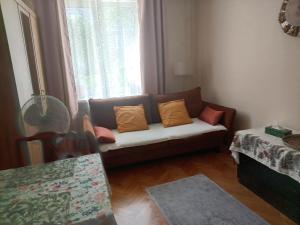a couch sitting in a living room with a window at E-Brechta in Warsaw