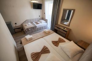 ein Hotelzimmer mit zwei Betten und einem Spiegel in der Unterkunft Hotel Petunia in Neos Marmaras