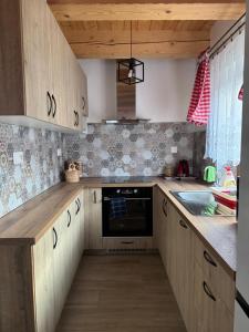 a kitchen with wooden cabinets and a stove top oven at Pallov Dvor in Lutiše +20 photos