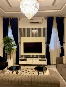 a living room with a couch and a television at St Kora Apartment and Shortlets in Asaba