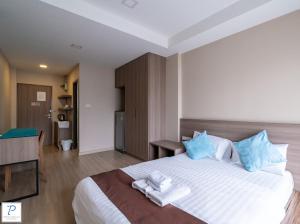 a bedroom with a large bed with towels on it at Perfect Smart Life Hotel in Ban Bang Toei (1)