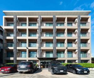 a large building with cars parked in front of it at Perfect Smart Life Hotel in Ban Bang Toei (1)