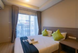 a hotel room with a bed with towels on it at Perfect Smart Life Hotel in Ban Bang Toei (1)