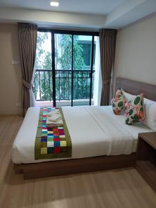 a bedroom with a large bed with a window at Perfect Smart Life Hotel in Ban Bang Toei (1)
