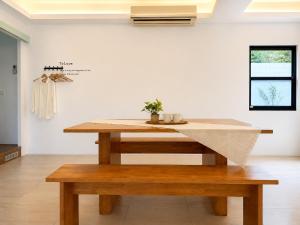 a dining table with a bench in a room at 若家民宿 台東縣民宿1275號 in Guanshan