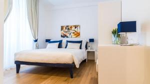 a bedroom with a king sized bed with blue pillows at Deki Relais in Sassari +16 photos