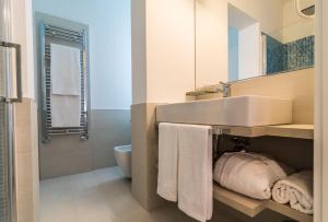 a bathroom with a sink and a toilet with towels at Deki Relais in Sassari