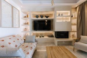 a living room with a couch and a tv at Naxos Royal Villas in Stelida