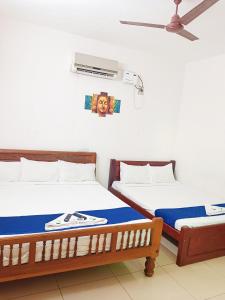 two beds sitting next to each other in a room at De Township beach in Pondicherry