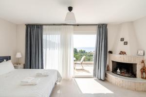a bedroom with a bed and a fireplace and a window at GAIAeMARE Suit Apartment in Pesádha