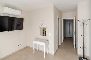 a white room with a white table and a mirror at GAIAeMARE Suit Apartment in Pesádha