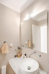 a white bathroom with a sink and a mirror at GAIAeMARE Suit Apartment in Pesádha +121 photos