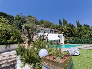 a garden with a swimming pool and a house at Rose in Portorož