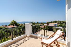 a balcony with a chair and a view of the ocean at GAIAeMARE Suit Apartment in Pesádha