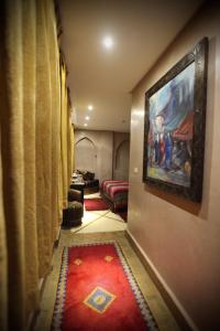 a hallway with a red rug and a painting on the wall at Riad Dar Haven in Tamraght Ou Fella