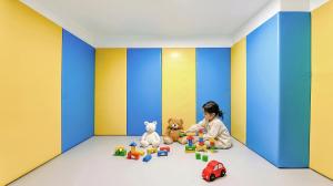 a child sitting in a room playing with toys at Goseong Belossi Ayajin Kids Poolvilla in Goseong