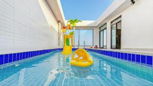a swimming pool with a yellow slide in the middle at Goseong Belossi Ayajin Kids Poolvilla in Goseong +12 photos