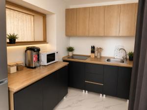a kitchen with black cabinets and a microwave at Mestia Central Apartment in Mestia
