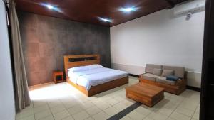 a bedroom with a bed and a couch in it at Eimas Hive in Kerobokan +20 photos