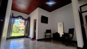 an empty room with two chairs and a large window at Eimas Hive in Kerobokan