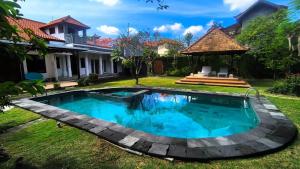 a swimming pool in the yard of a house at Eimas Hive in Kerobokan