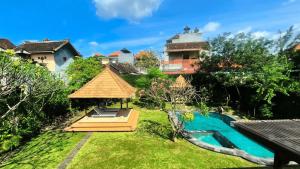 a view of a garden with a swimming pool at Eimas Hive in Kerobokan