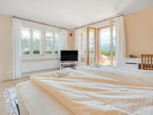 a large bedroom with two beds and a television at Luxury Alpine Chalet with incredible Views in Lenk +35 photos