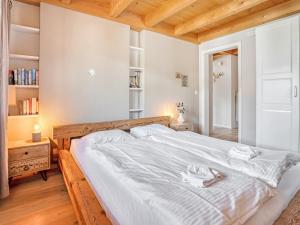 a bedroom with a large bed with white sheets at Luxury Alpine Chalet with incredible Views in Lenk