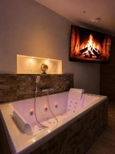 a large bath tub in a room with a fireplace at Coin détente in Vierzon