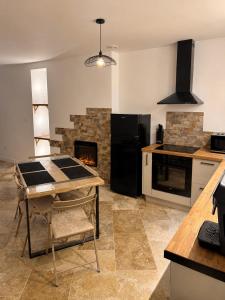 a kitchen with a table and a fireplace at Coin détente in Vierzon