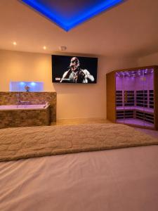 a bathroom with a tv on the wall and a sink at Coin détente in Vierzon