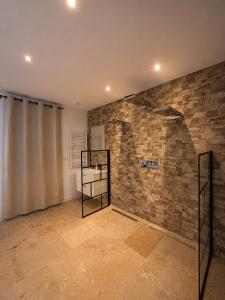a room with a brick wall and a glass shelf at Coin détente in Vierzon