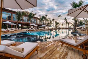 a pool at the resort with chairs and umbrellas at Anaya Hotel Zanzibar in Pwani Mchangani