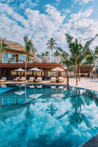 a swimming pool in front of a resort with palm trees at Anaya Hotel Zanzibar in Pwani Mchangani