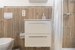 ein Badezimmer mit Toilette und weißem Waschbecken in der Unterkunft Meerblickbude in Wendtorf + 19 Fotos