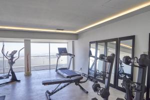 a gym with several tread machines and a large window at Alfândega da Fé Hotel & SPA in Sambade