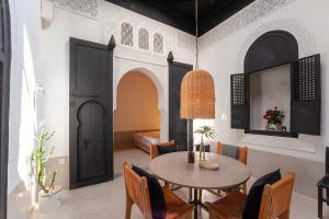 a dining room with a table and chairs and a bedroom at Riad Sahara - Private House Rooftop Medina Marrakech in Marrakesh