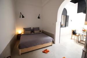 a bedroom with a bed in a room with a table at Riad Sahara - Private House Rooftop Medina Marrakech in Marrakesh