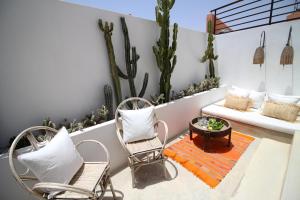 a patio with chairs and a coffee table and cactus at Riad Sahara - Private House Rooftop Medina Marrakech in Marrakesh
