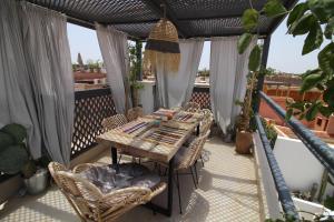 a wooden table and chairs on a balcony at Riad Sahara - Private House Rooftop Medina Marrakech in Marrakesh +20 photos