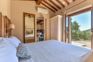 a bedroom with a bed and a large window at Agriturismo Galenzana in Marina di Campo +68 photos